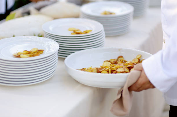 Waiter serving a large bowl of tasty fried potatoes