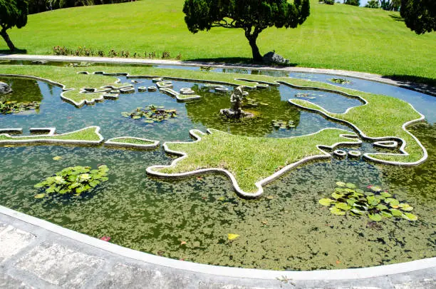 A map of Bermuda lies in a water garden in a public park in Bermuda