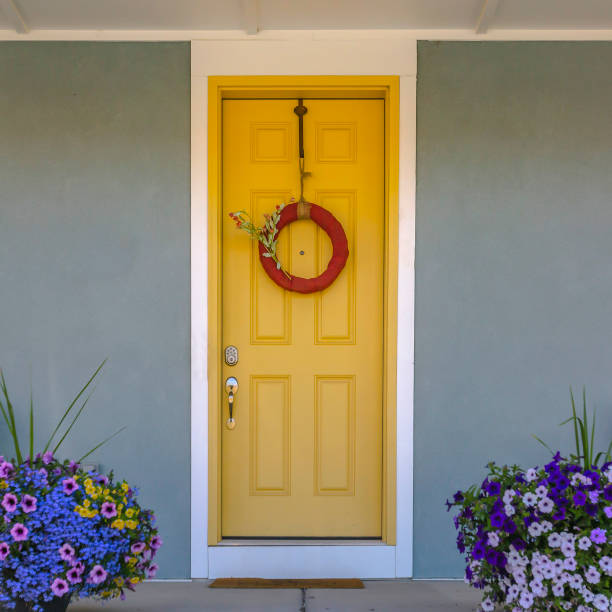 istock Front door with wreath and colorful potted flowers 1056085882