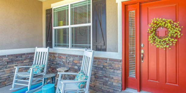 istock Red front door with wreath and chairs on porch 1056105114
