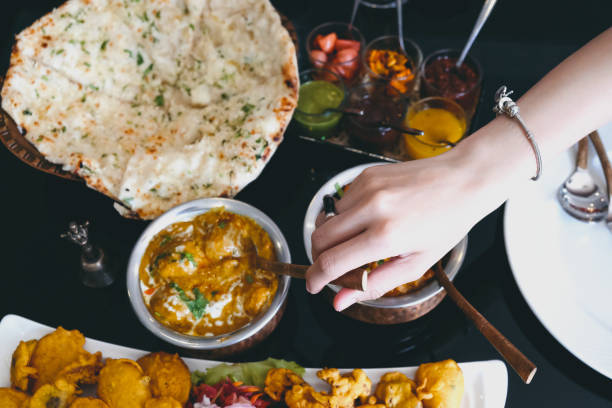 istock woman's hands as she is having Indian food. 1056115902