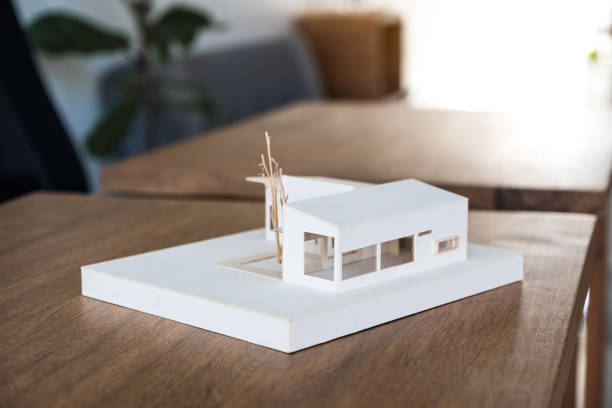 istock An architecture model on wooden table in office with blur nature background 1056120724