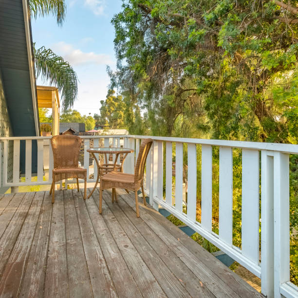 istock Wicker chairs and table on a balcony beside trees 1056124384