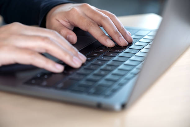 istock Closeup image of hands using and typing on laptop keyboard on table 1056144164