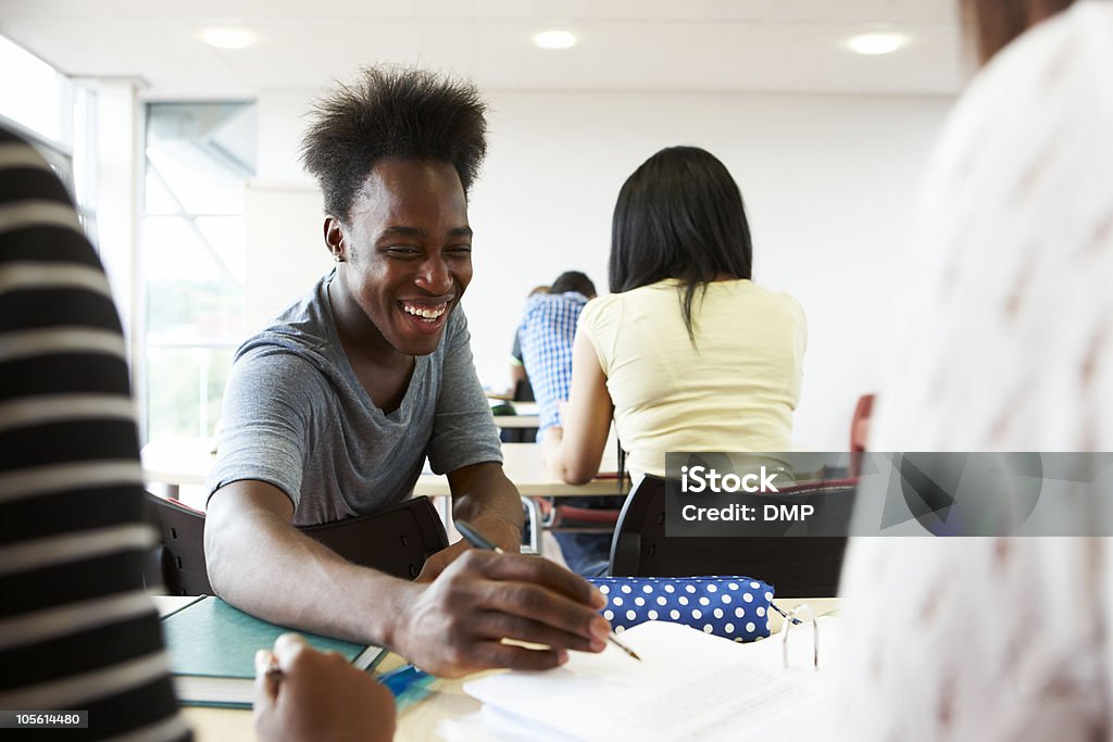 Confiant mâle étudiant heureux avec des amis dans une salle de classe - Photo de Adolescent libre de droits
