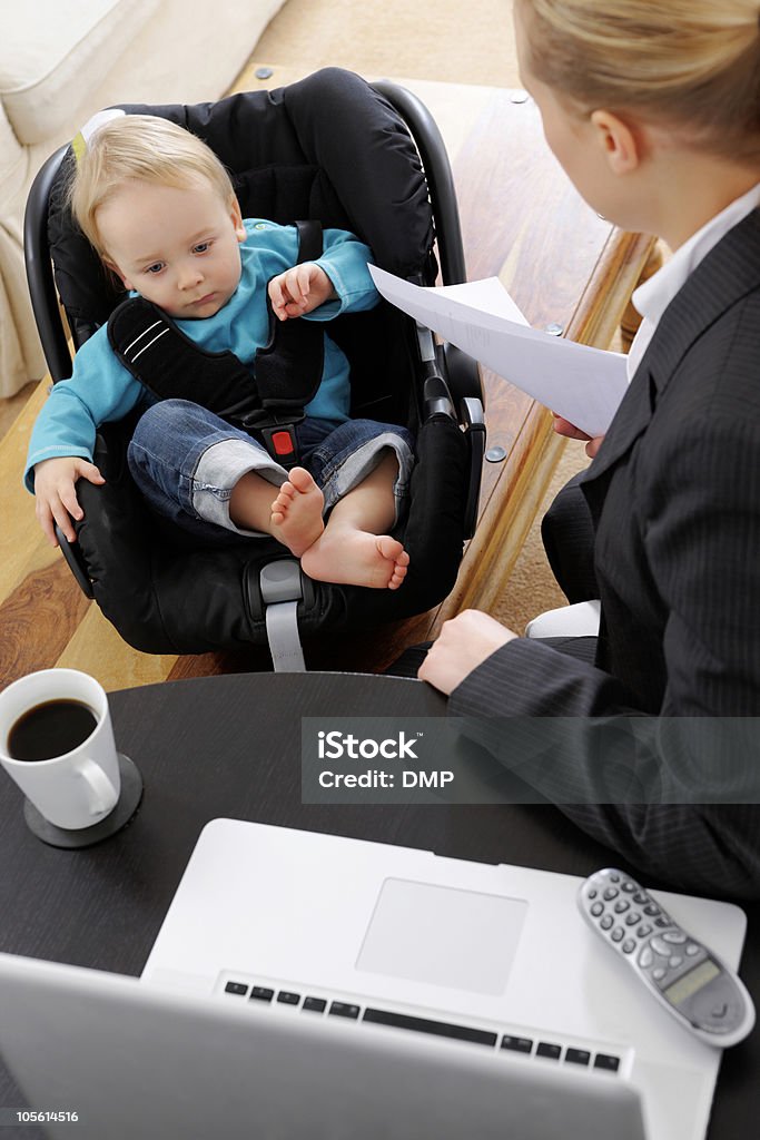 Negócios mulher assistindo seu bebê, trabalhando em casa - Foto de stock de 25-30 Anos royalty-free