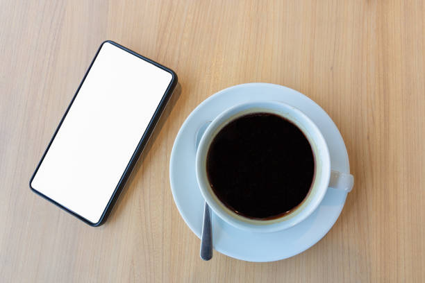 istock smartphone with blank white screen for mock up template background and cup of coffee cup 1056155838