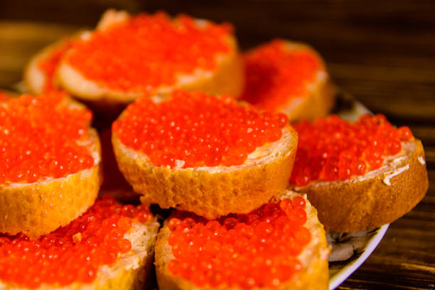 istock Sandwiches with red caviar on wooden table 1056156466