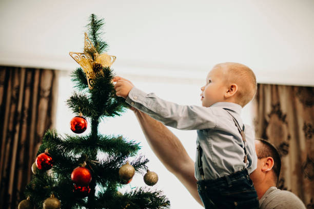 istock Father and boy putting star on Christmas tree 1056162314