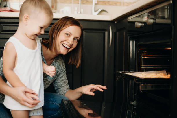 istock Laughing mother and son at stove 1056162316