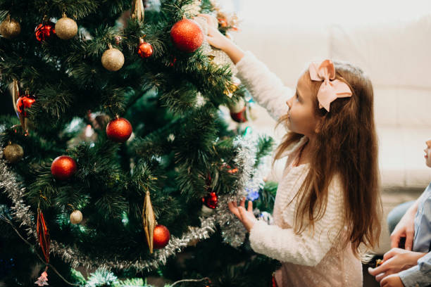 istock Girl putting bauble on Christmas tree 1056162318