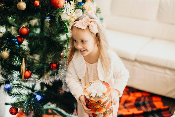 istock Charming little girl with Christmas present at home 1056162368