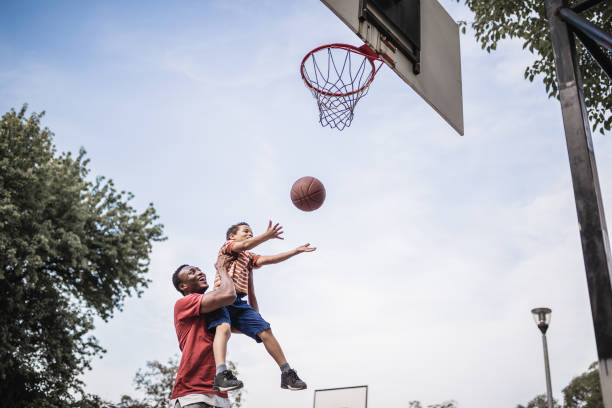 padre e figlio giocano a basket - action family photograph fathers day foto e immagini stock