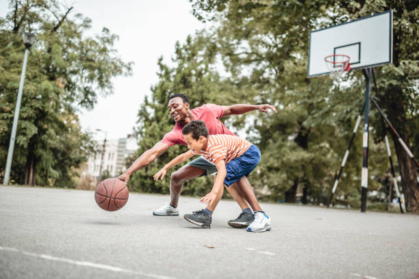 pai e filho jogando basquete - basketball child dribbling basketball player - fotografias e filmes do acervo