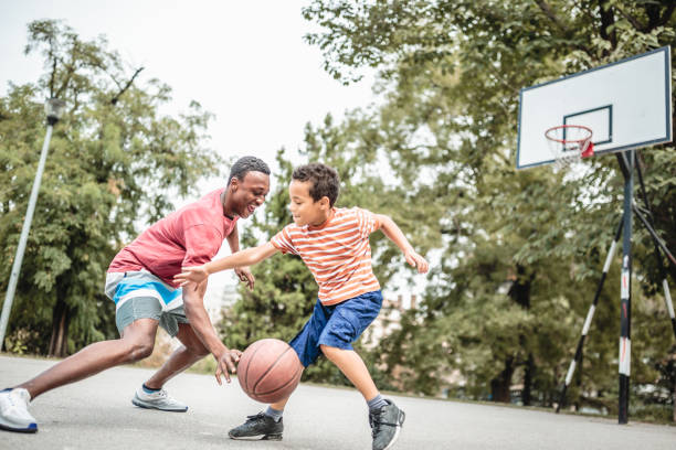 padre e figlio giocano a basket - action family photograph fathers day foto e immagini stock