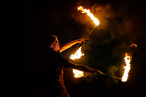 Fire show. Fakir dances with two Staff. Night performance. Fire and smoke. Fascinating flame movement. Subjugation of the elements of fire.