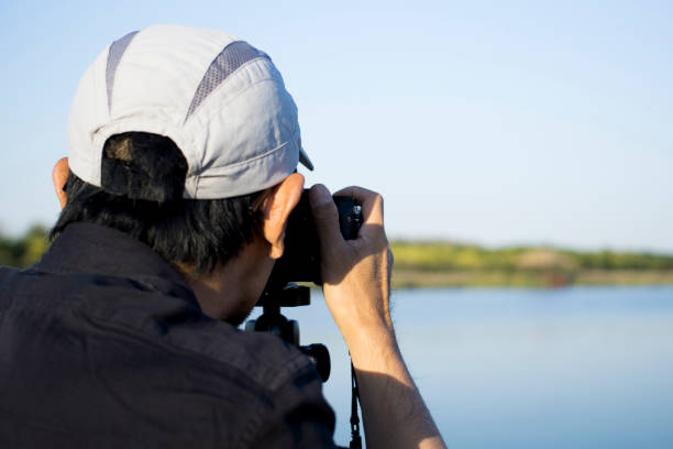 istock man taking pictures with camera in wetland 1056202622