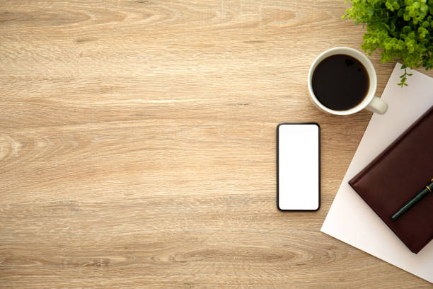 istock phone with isolated screen on wooden table near notebook coffee 1056204266