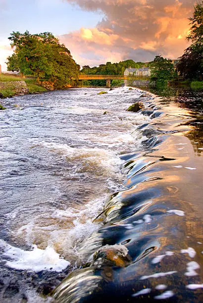 Water running over weir at evening at Grassington, Yorkshire Dales National Park, North Yorkshire, England