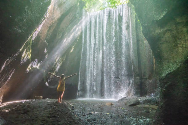 istock Happy young woman enjoying waterfall discovery 1056205456