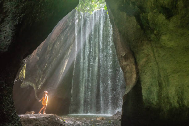 istock young woman illuminated by sunbeam in waterfall 1056205714
