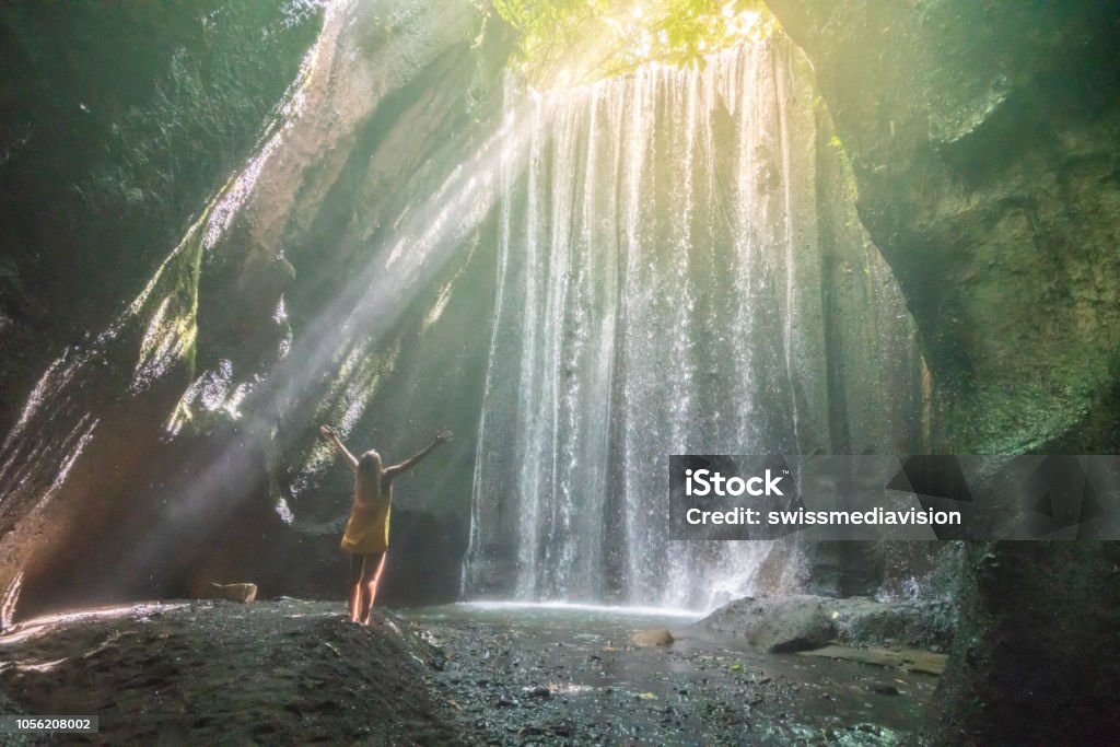 Traveling young woman arms outstretched in tropical rainforest in Bali embracing the beauty in nature. People travel nature concept. Happiness Stock Photo