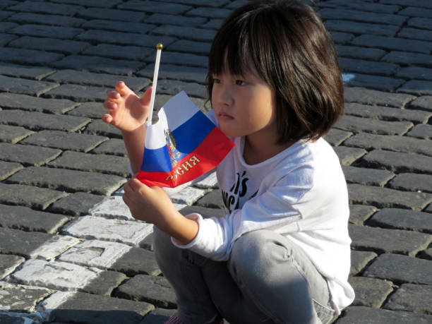 la bambina asiatica che gioca con la bandiera russa per strada - russian culture russia child people foto e immagini stock