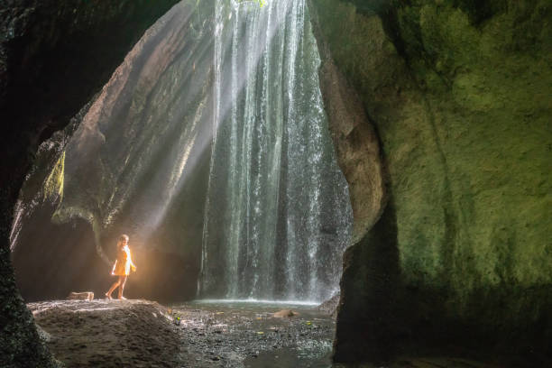 istock Woman discovering secret waterfall in tropical paradise 1056208322