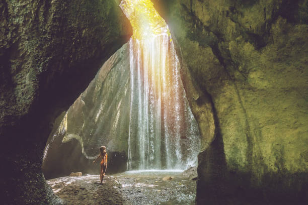 istock Woman discovering secret waterfall in tropical paradise 1056208374