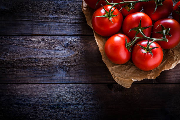 istock Fresh ripe tomatoes on crumpled brown paper still life 1056210516