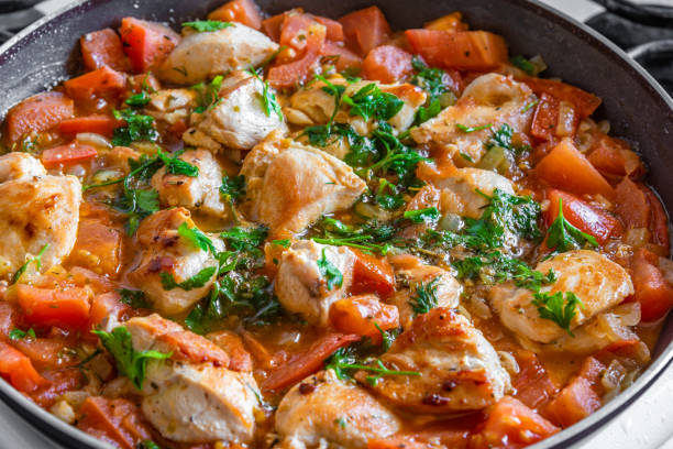istock Chicken cacciatore is cooked in a frying pan, chicken stew with tomatoes and red pepper - top view 1056212420