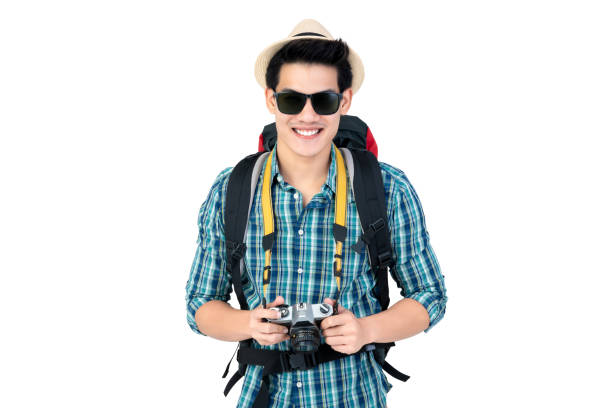 istock Smiling young handsome Asian tourist man carrying backpack and holding camera 1056215010