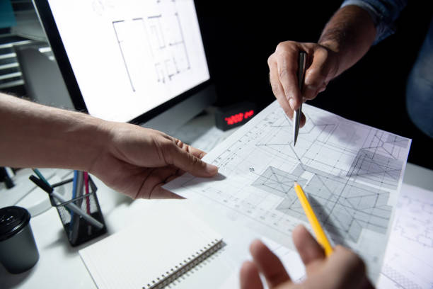 istock Architect team discussing blueprint paper in office at night 1056215160