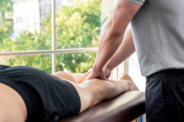 piernas dando terapeuta masculino masaje paciente atleta en clínica - massaging men swedish culture male fotografías e imágenes de stock