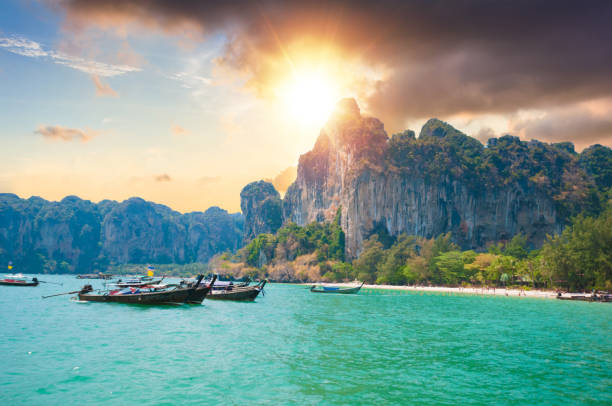 beau coucher de soleil en mer tropicale avec bateau longue queue dans le sud de la thaïlande - phuket province photos et images de collection