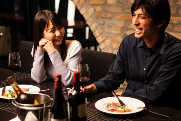 男性はガール フレンドとレストランでワインを飲む - レストラン　日本 ストックフォトと画像