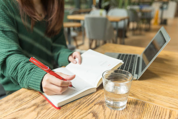 istock A  girl writing on her notebook in a cafe 1056221106