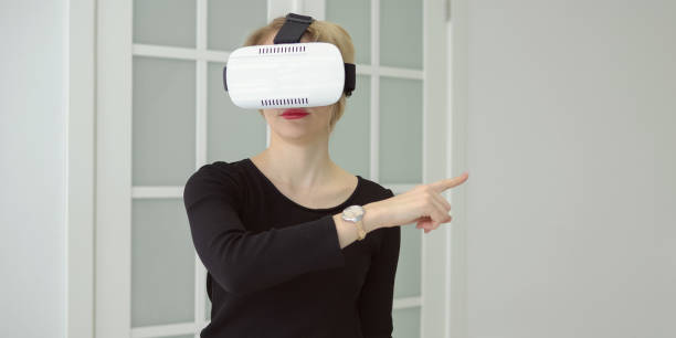 istock Confident young woman in virtual reality headset 1056222892