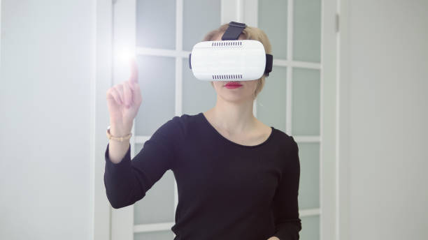 istock Young woman getting experience using VR headset glasses of virtual reality 1056222904