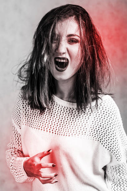 istock Screaming young woman in a white sweater 1056225996