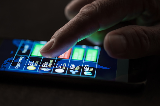 New york, USA - July 25, 2018: Man checking cryptocarrencies exchange to dollar rate on smartphone display.