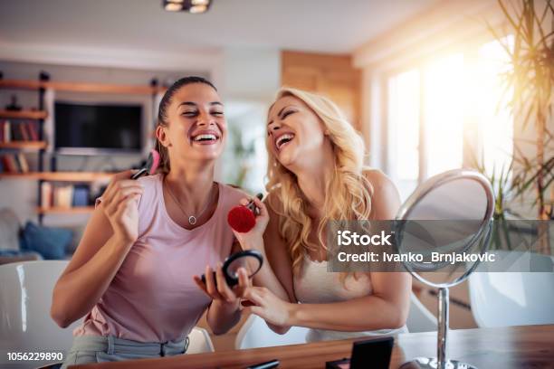 Two Happy Girls Applying Make Up At Home Stock Photo - Download Image Now - Make-Up, Women, Friendship