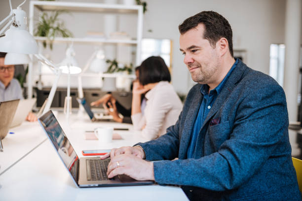 porträt von reifer geschäftsmann im coworking-space - heavy plant stock-fotos und bilder