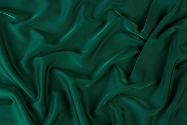 istock Green silk fabric background, view from above 1056235988
