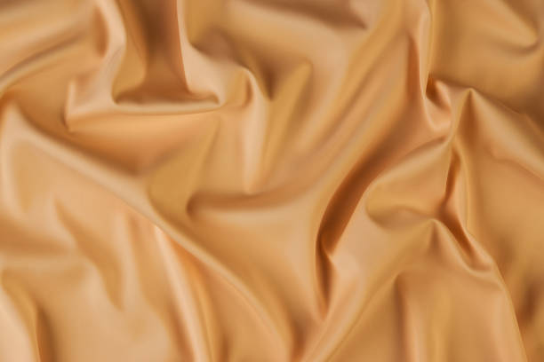 istock Beige silk fabric background, view from above 1056236082