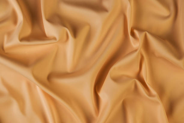 istock Beige silk fabric background, view from above 1056236086