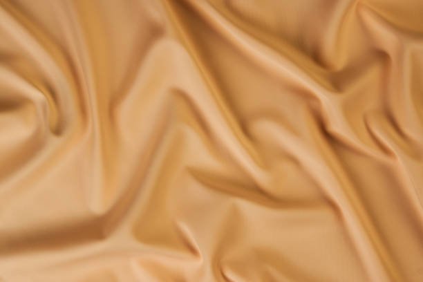 istock Beige silk fabric background, view from above 1056236092