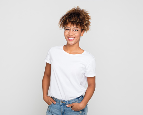 Portrait of stylish afro american woman in casuals wearing eyeglasses on grey background