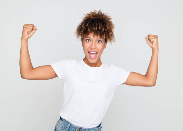 istock Excited african woman flexing her biceps 1056238658