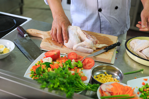 Asian chef preparing chicken meat